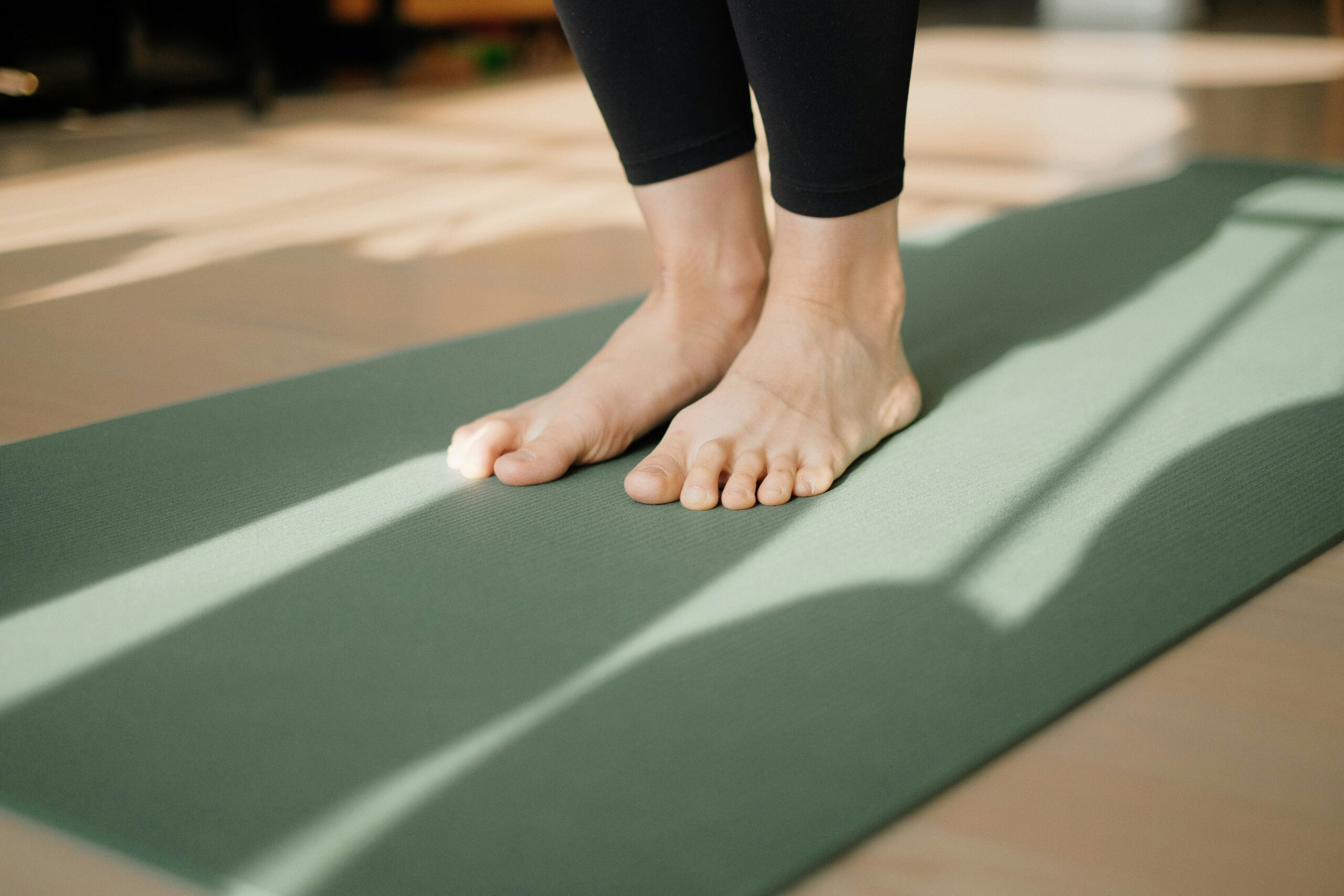 Person sitting cross-legged on a mat taking deep breaths